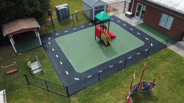 Green rubber playground with a custom road-pattern border