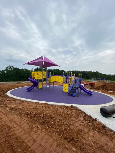 Purple rubber surfacing surrounding a playground